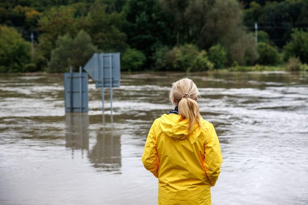 woman stares into flood waters